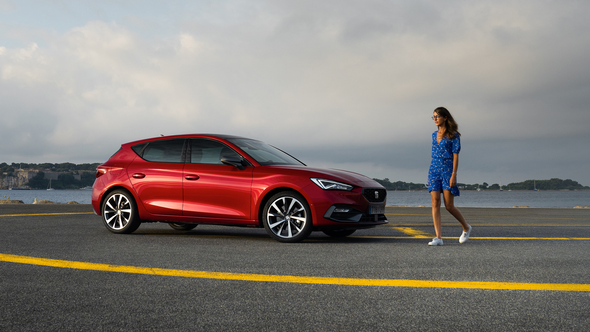 Vrouw loopt naast SEAT Leon