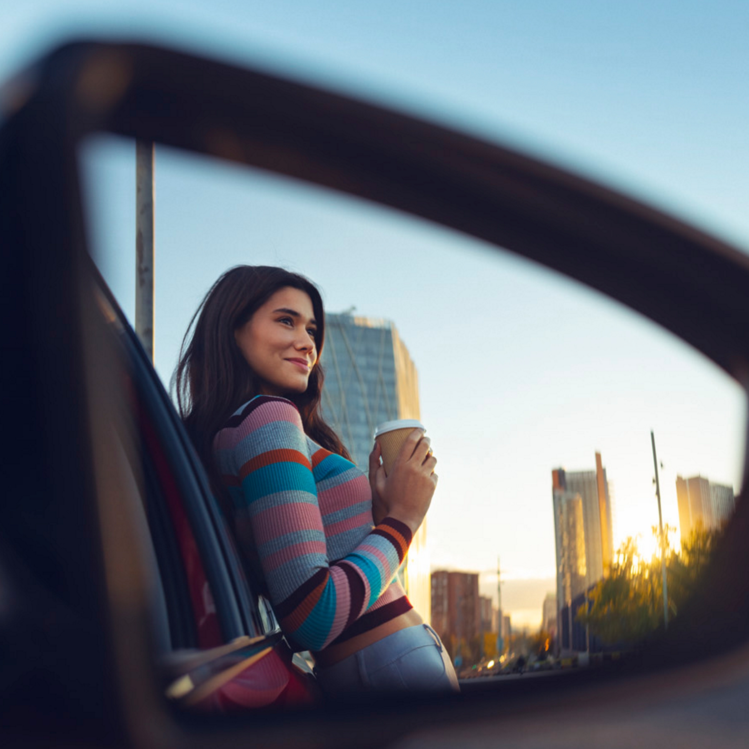 Vrouw met koffie in autospiegel