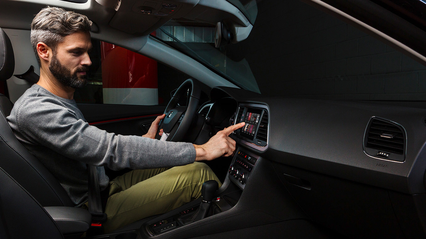 Man drukt op touchscreen in SEAT Leon