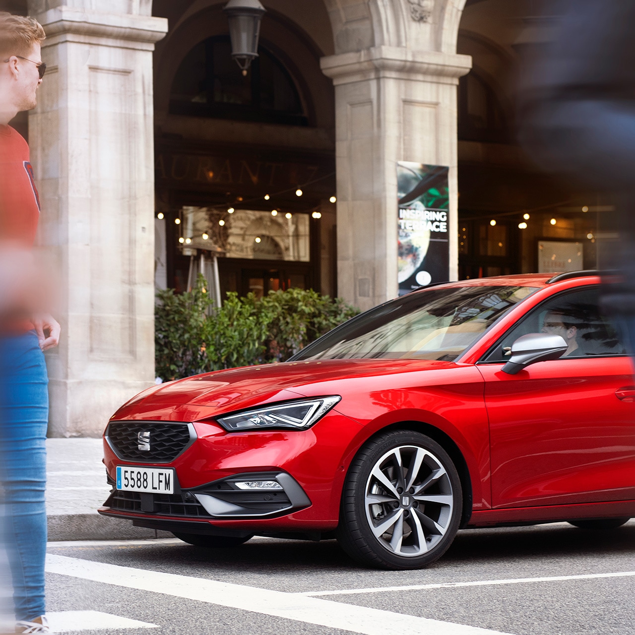 SEAT Leon FR mild hybrid hatcback in Desire Red in een drukke stad bij het voetganger oversteekplaats