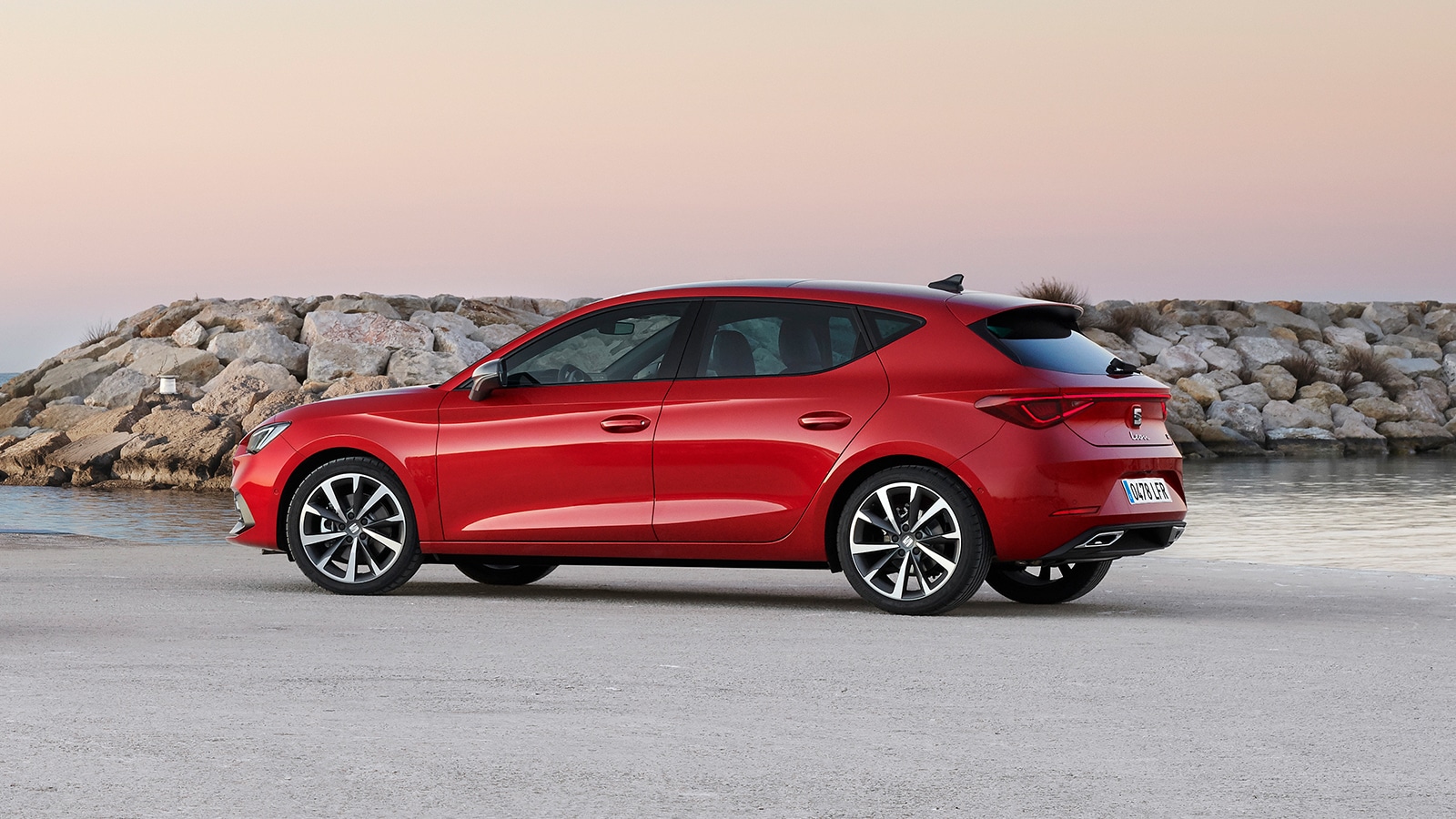 SEAT Leon FR mild hybrid hatcback in Desire Red aan de kust op het strand