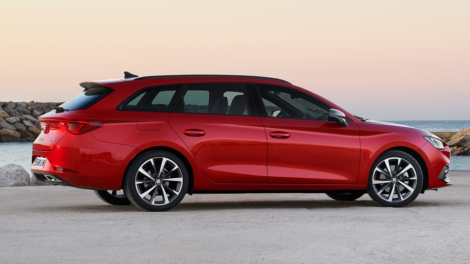 SEAT Leon Sportstourer FR mild hybrid stationwagen in Desire Red aan de kust op het strand