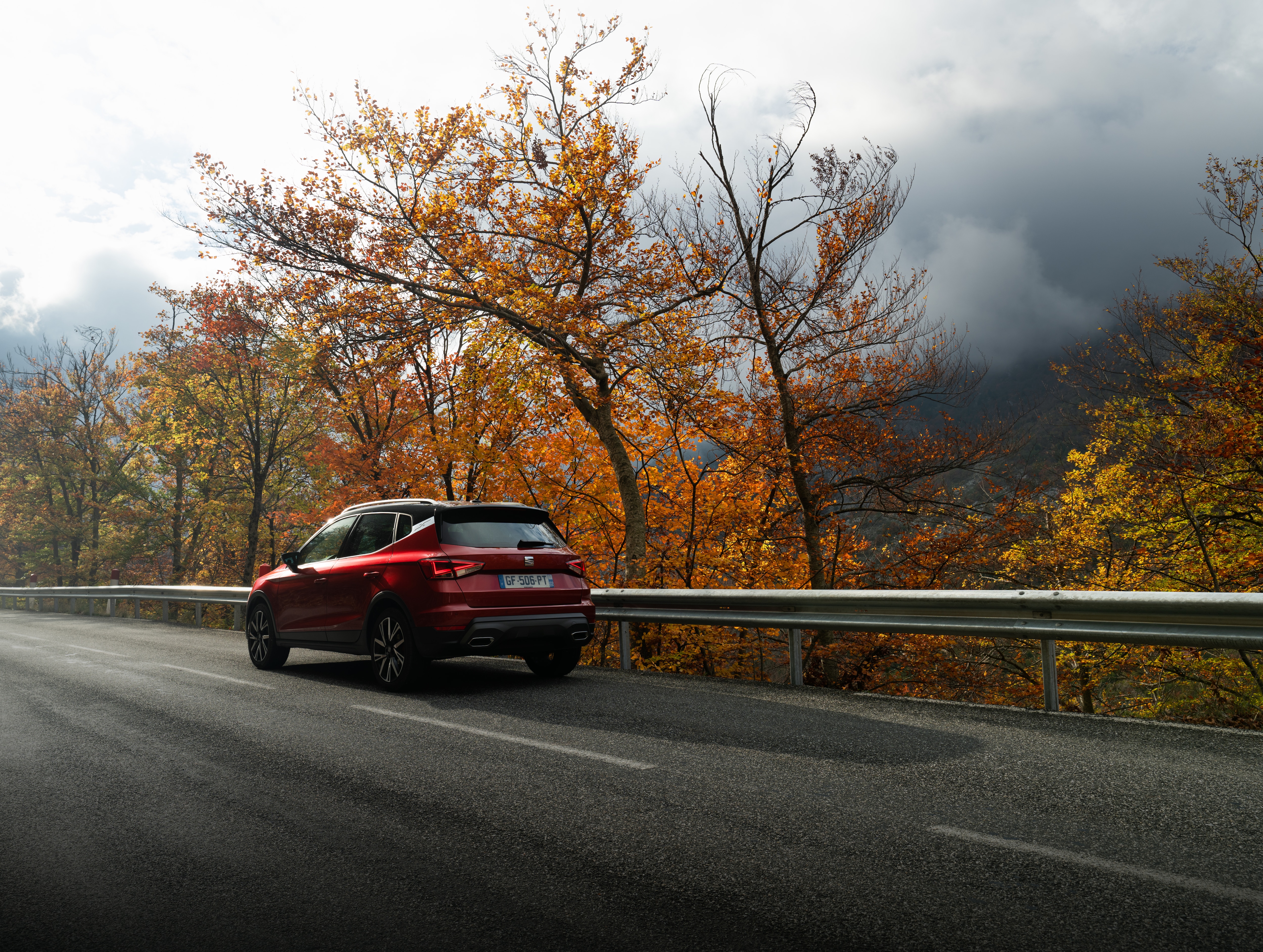 Achteraanzicht van rode SEAT Arona rijdend op de weg
