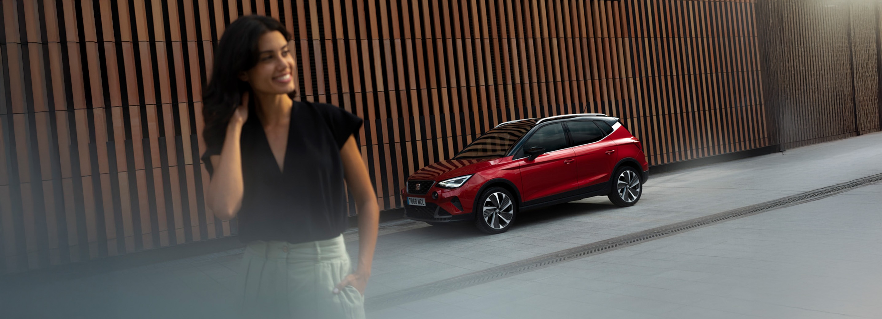 Vrouw met op de achtergrond rode SEAT Arona FR