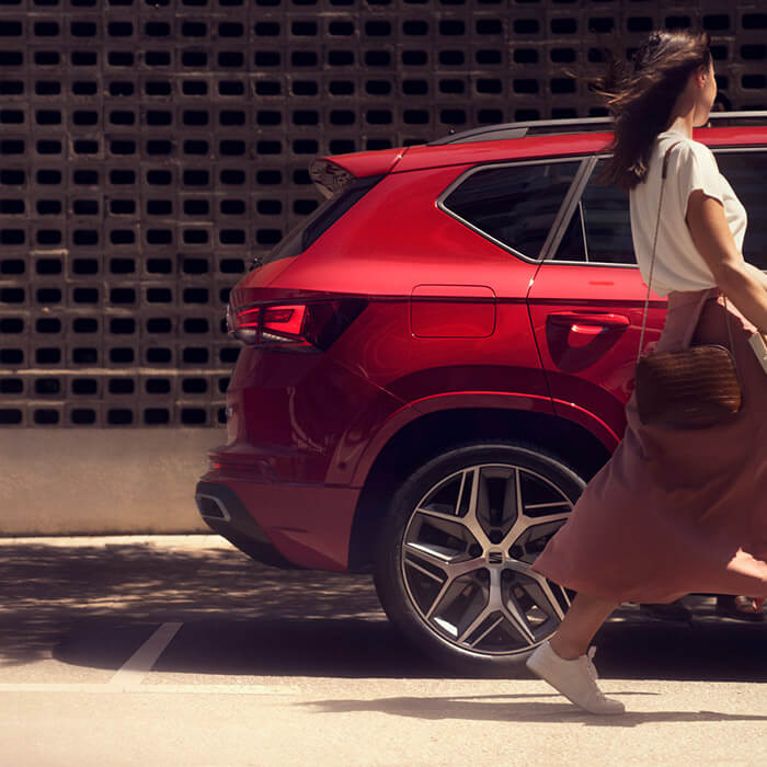 SEAT Leon hatchback 2025 plug in hybrid electric vehicle. Parked and charging outdoors, featuring spoke alloy wheels, interior ambient lighting and heated front seats for optimal comfort.