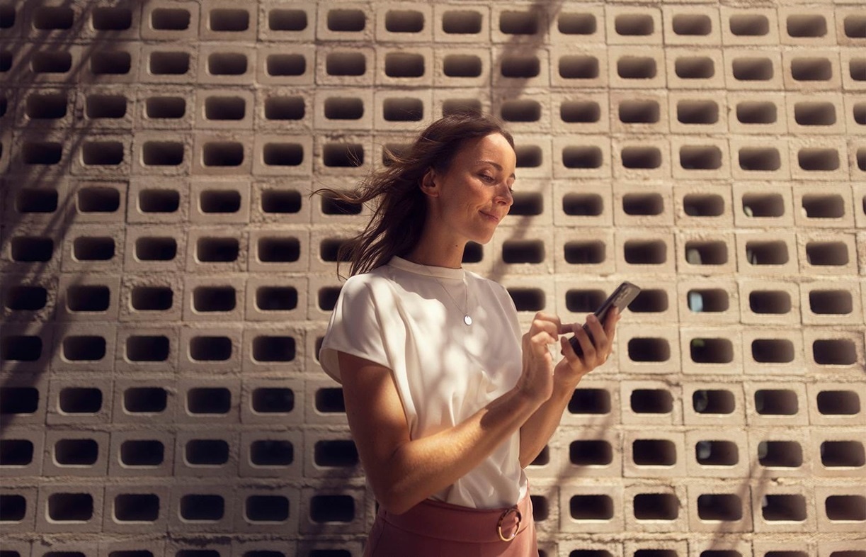 Vrouw glimlachend naar haar mobiele telefoon