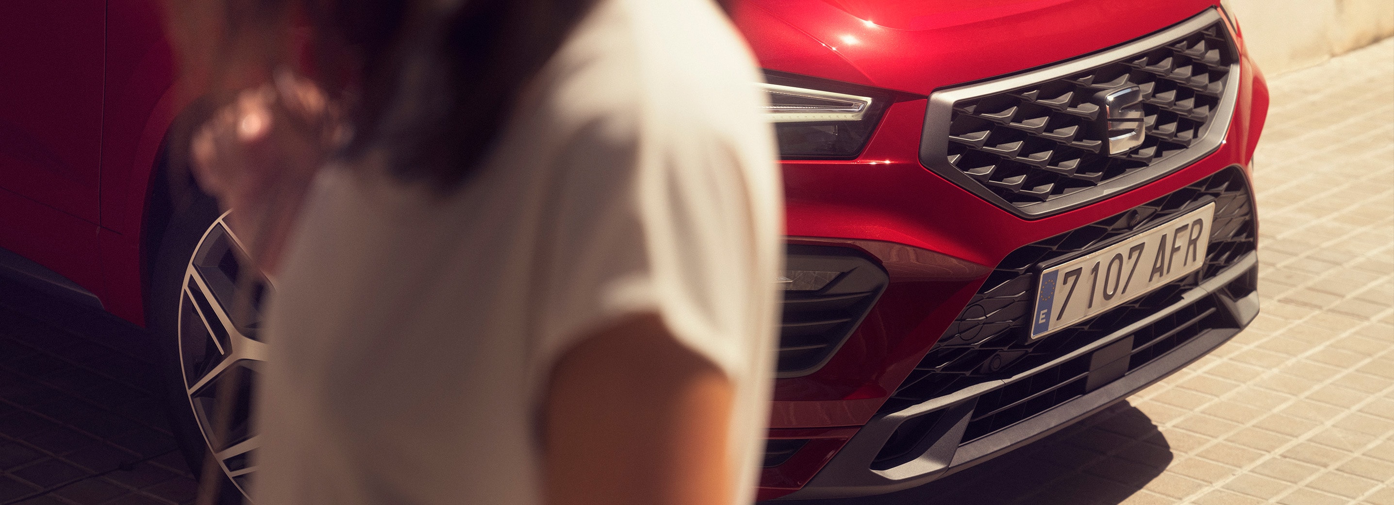 Vrouw naast rode SEAT Ateca FR