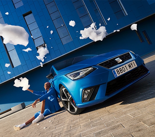 Man die met schuim speelt naast een blauwe SEAT Ibiza