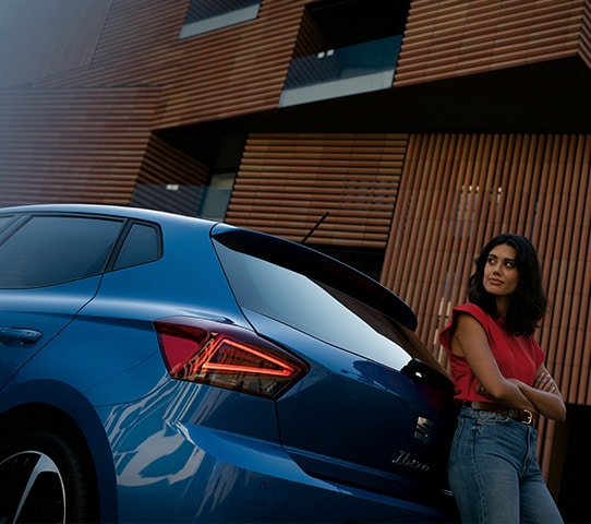 Blauwe SEAT Ibiza met vrouw ernaast