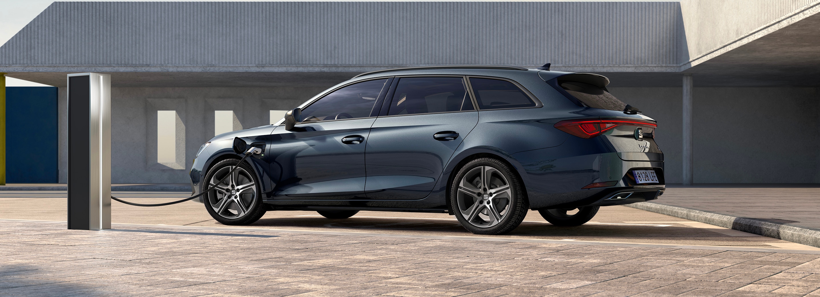 Grijze SEAT Leon Sportstourer in hybride uitvoering, aan de laadpaal