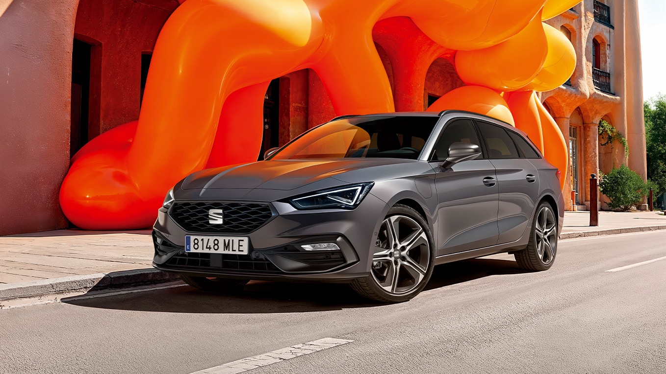 Grijze SEAT Leon Sportstourer met kleurrijke vormen op de achtergrond