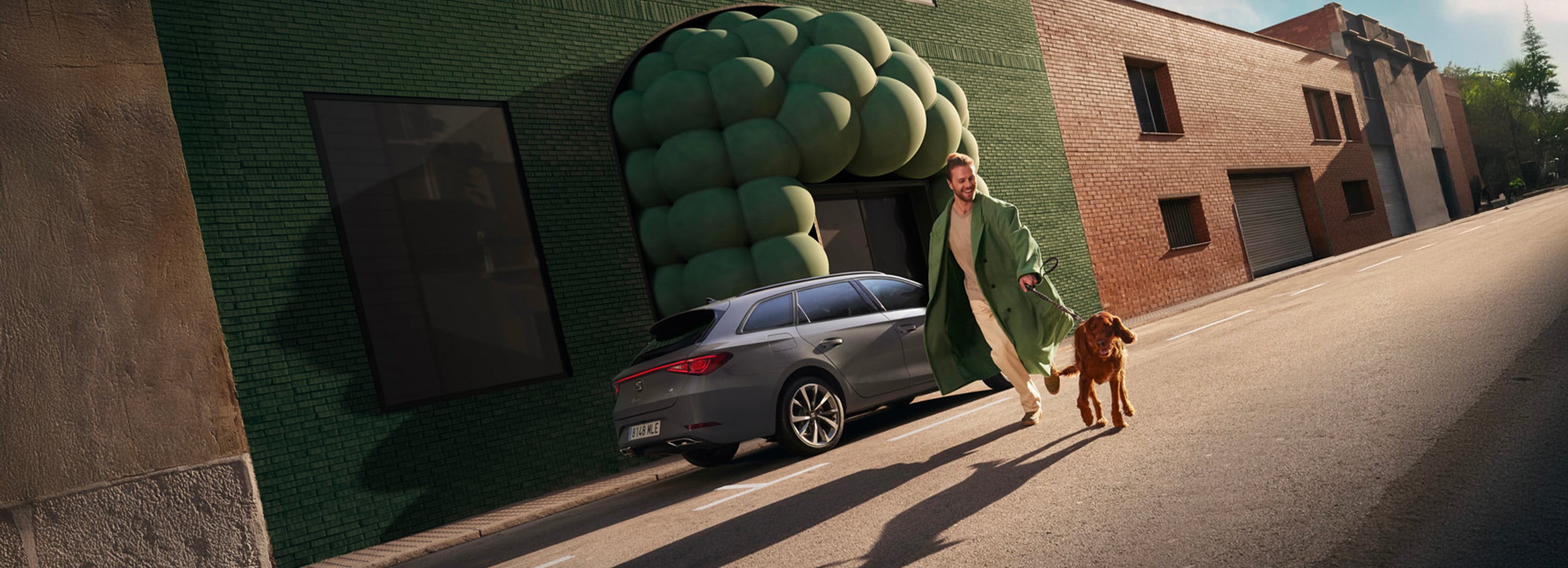 Man met hond naast de grijze SEAT Leon Sportstourer