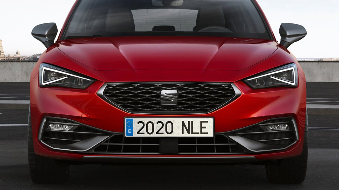 Een close-up van de voorgrille van de Seat Leon in Desire Red, waarin het gedurfde en verfijnde honingraatpatroon wordt getoond.