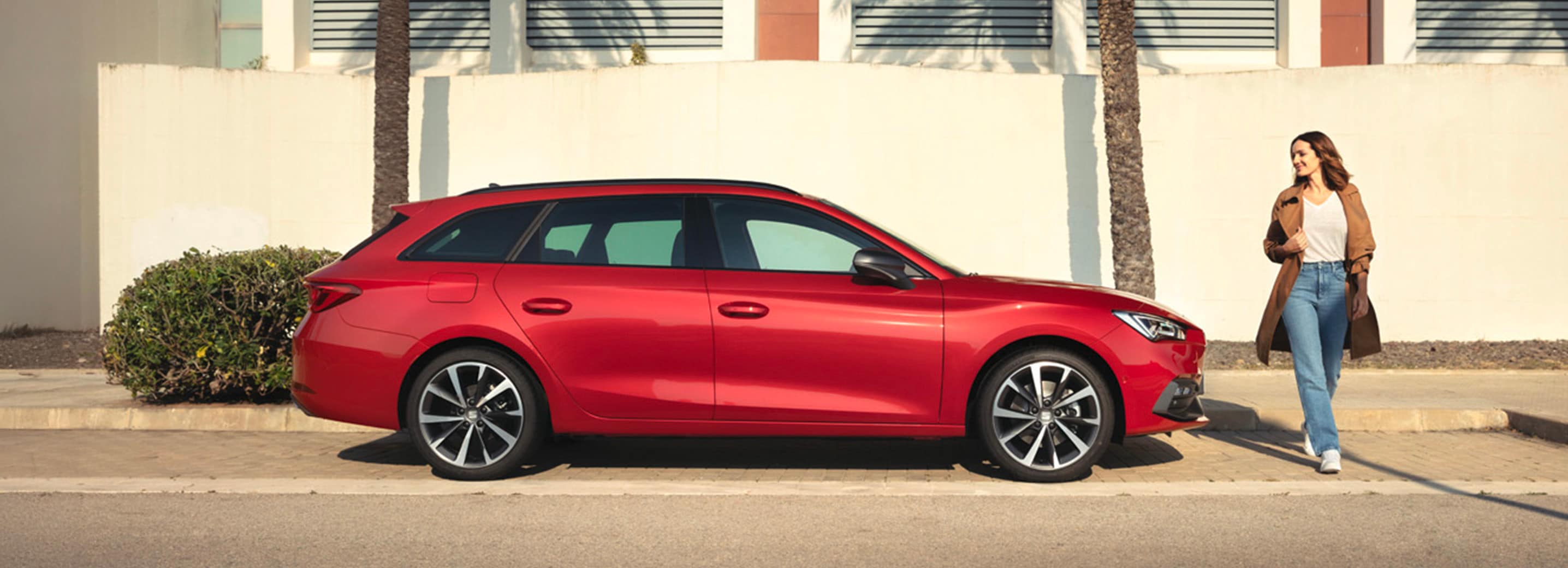 Vrouw naast rode SEAT Leon Sportstourer