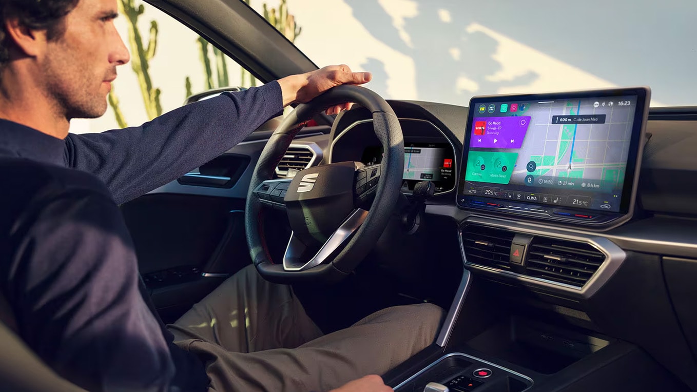 Man aan het stuur van de SEAT Leon, met daarin het infotainmentsysteem