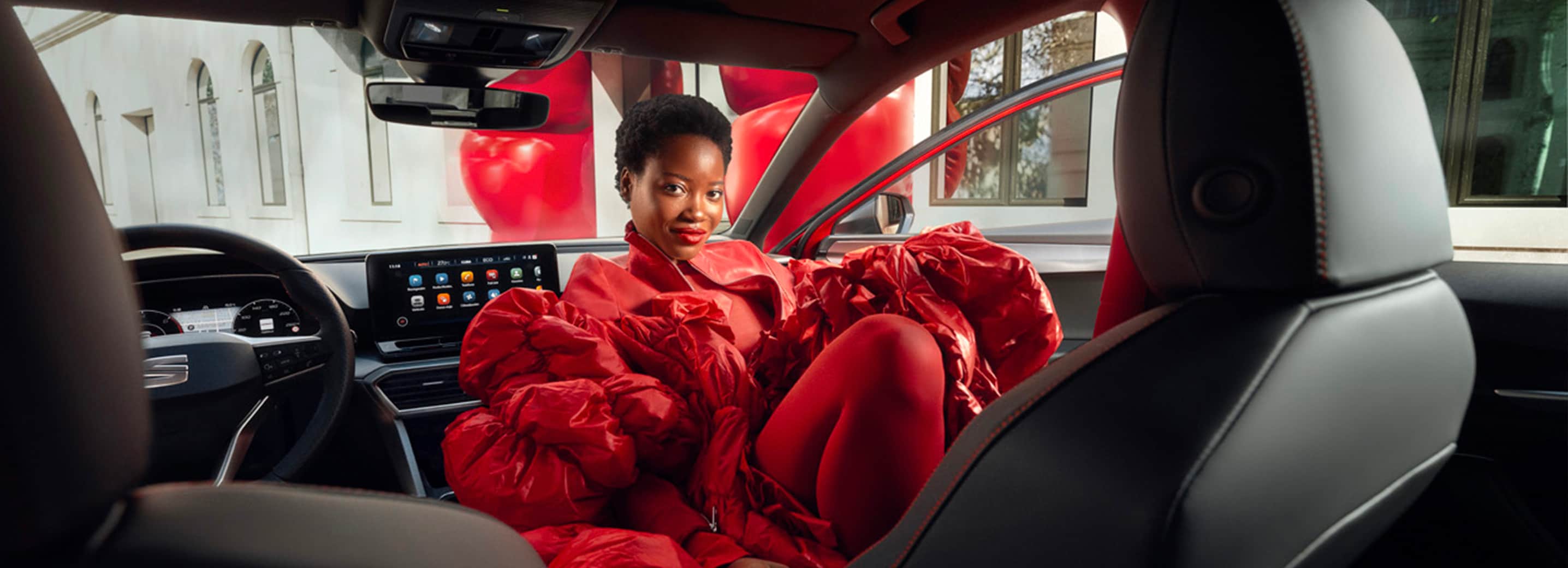 Vrouw in rood gewaad in de SEAT Leon