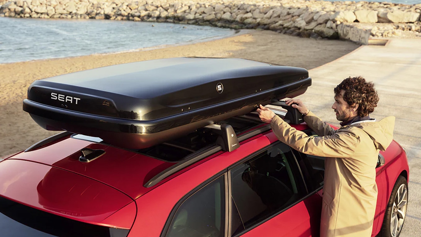 Bagagebox op een SEAT Leon met man ernaast