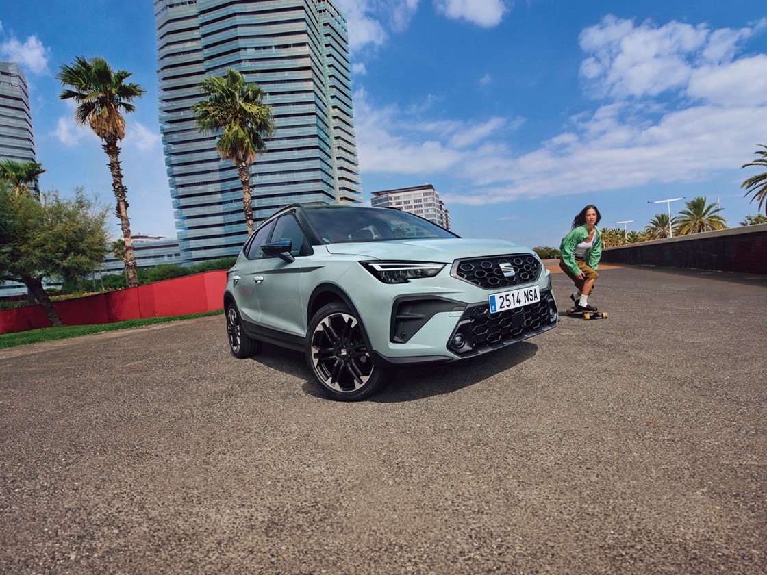 De nieuwe SEAT Arona met een vrouw op skateboard ernaast