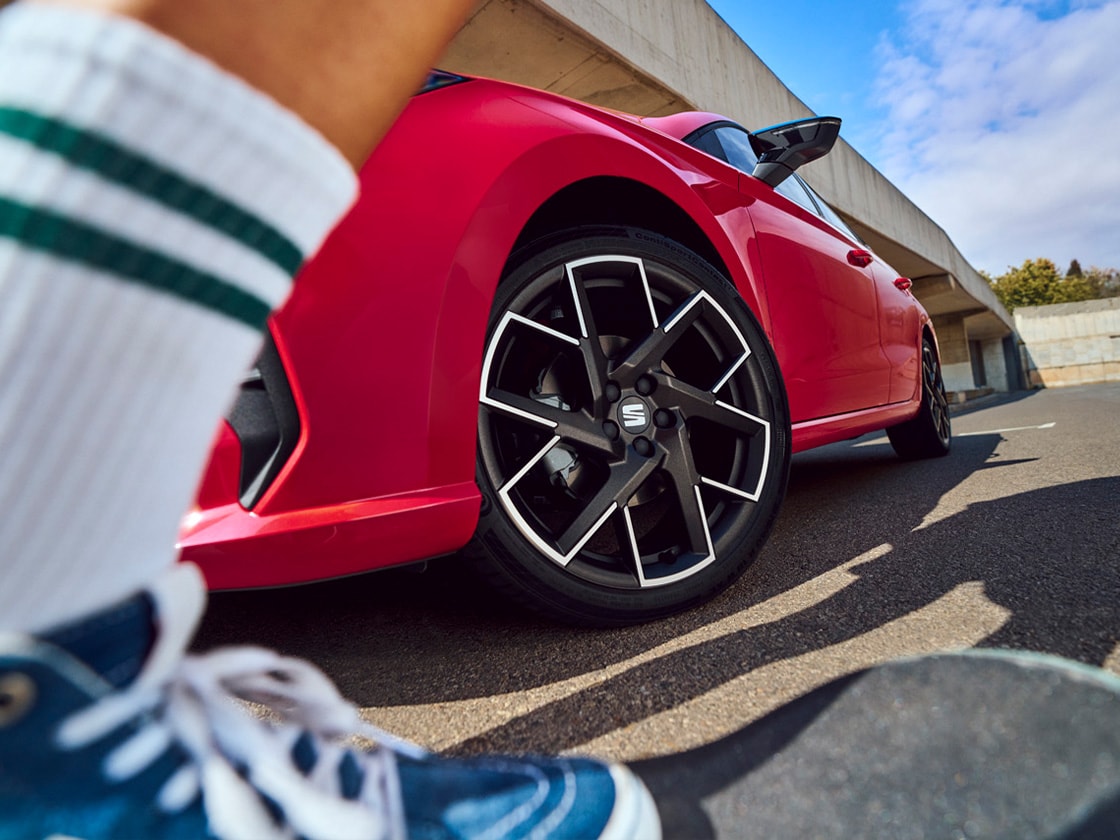 Vrouw lopend naast blauwe SEAT Ibiza