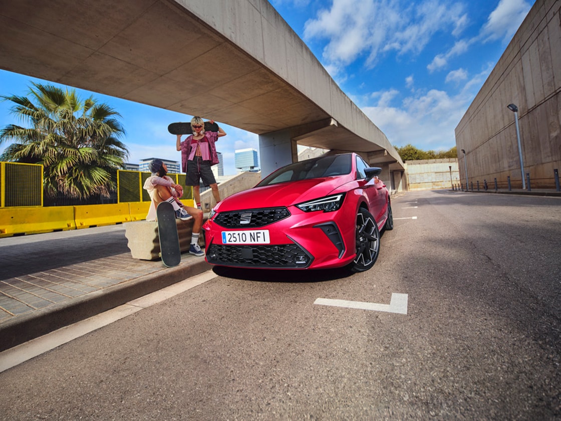 Rode SEAT Ibiza met twee personen ernaast