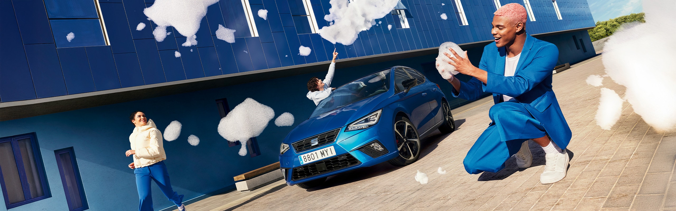 Blauwe SEAT Ibiza FR, met daaromheen mensen die met badschuim spelen