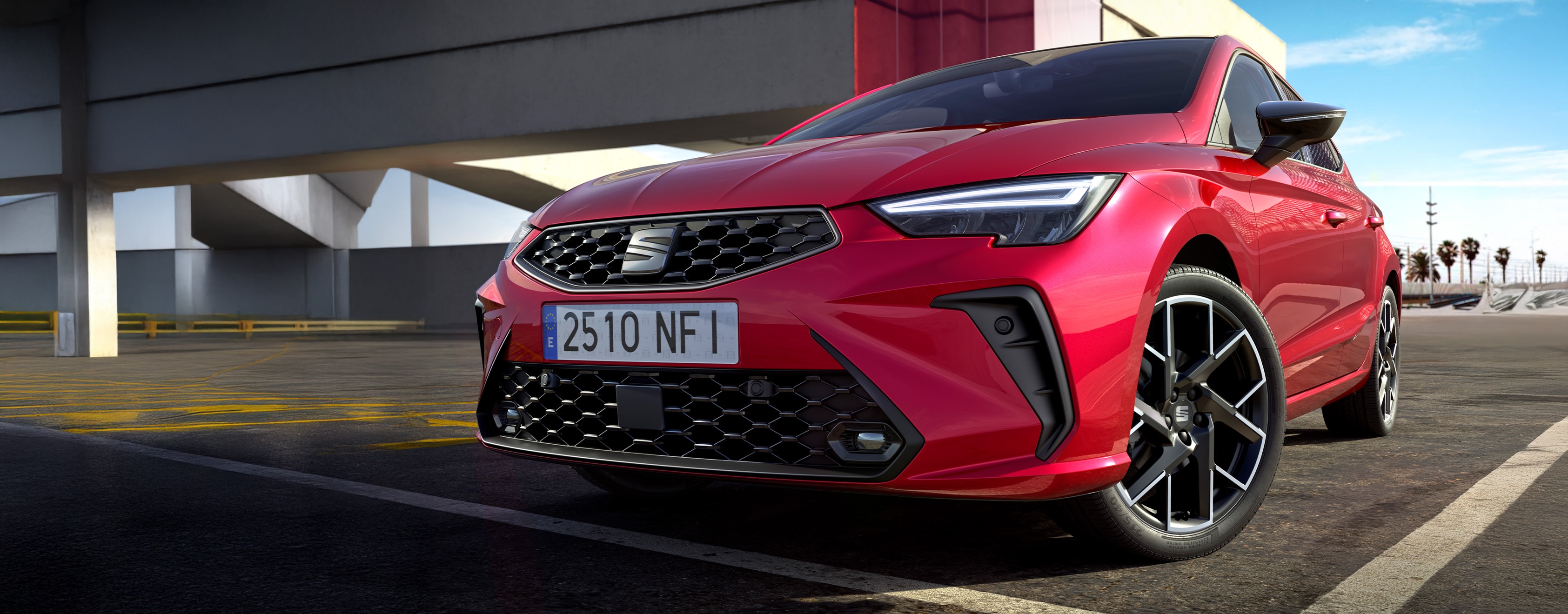 lachende vrouw staat voor een blauwe SEAT Ibiza