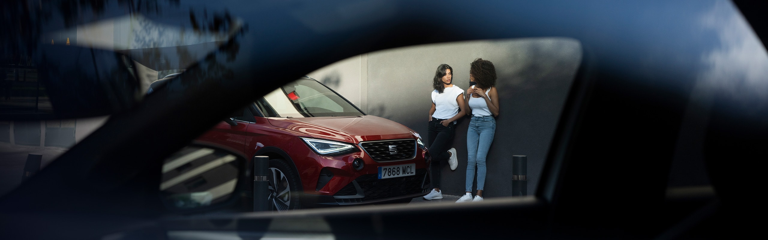 Lachende vrouw met op de achtergrond een rode SEAT Arona