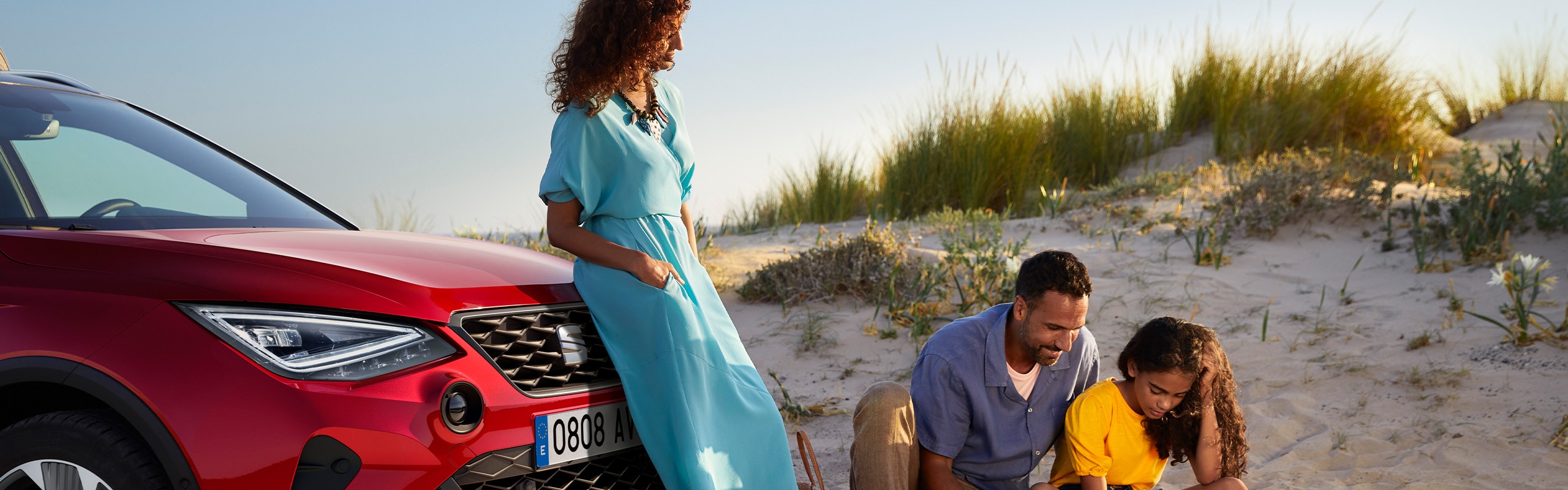 Vrouw met ogen dicht naast een rode SEAT Arona