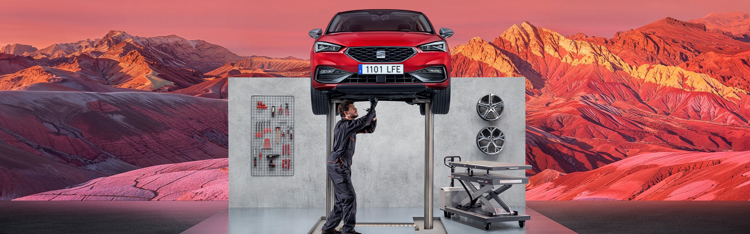 Monteur die onder een SEAT Leon staat te sleutelen op de werkplaats