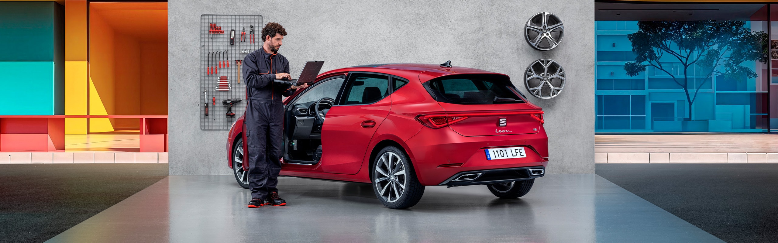 Monteur staat met laptop naast een SEAT Leon in de werkplaats