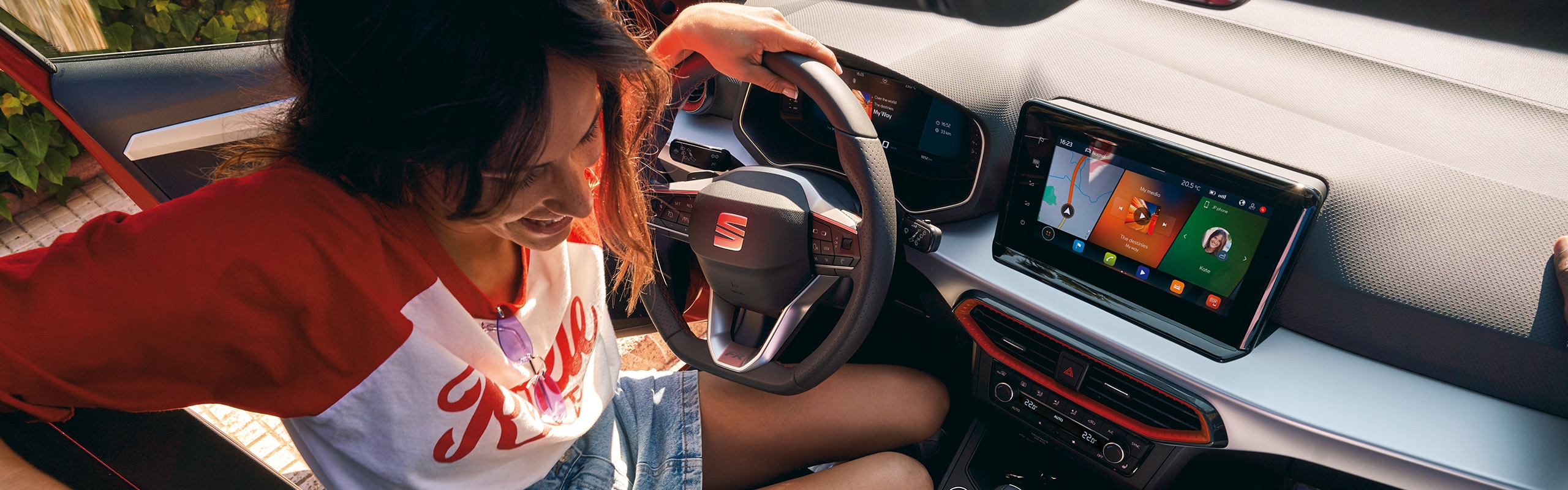 Vrouw zit achter het stuur van een seat ibiza en lacht naar de man die naast haar zit