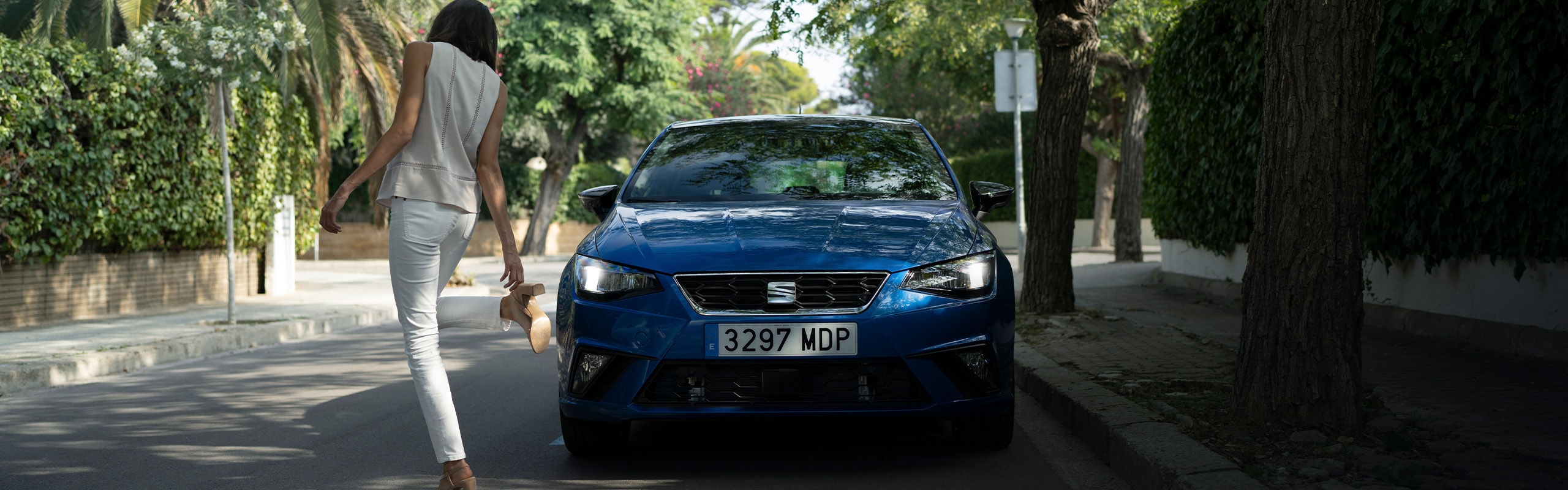 Vrouw die naast een blauwe SEAT Ibiza FR staat