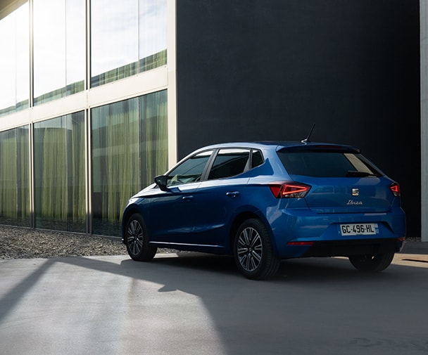 Blauwe SEAT Ibiza geparkeerd bij een kantoorgebouw