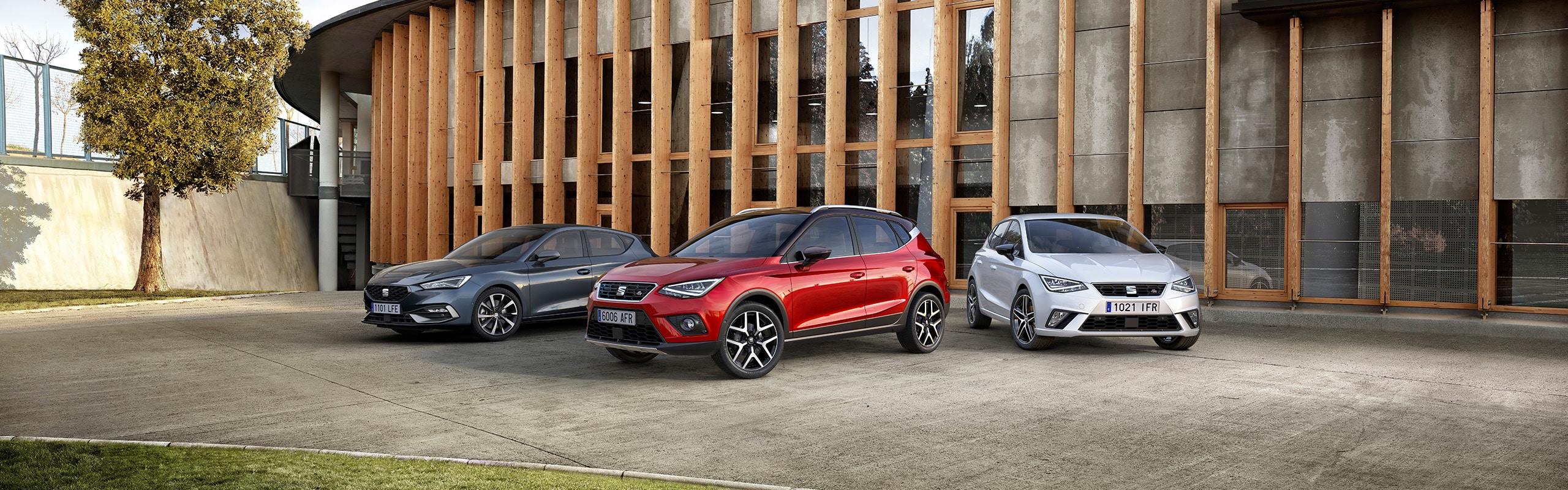 SEAT Leon, SEAT Arona en een SEAT Ibiza geparkeerd voor een kantoorgebouw