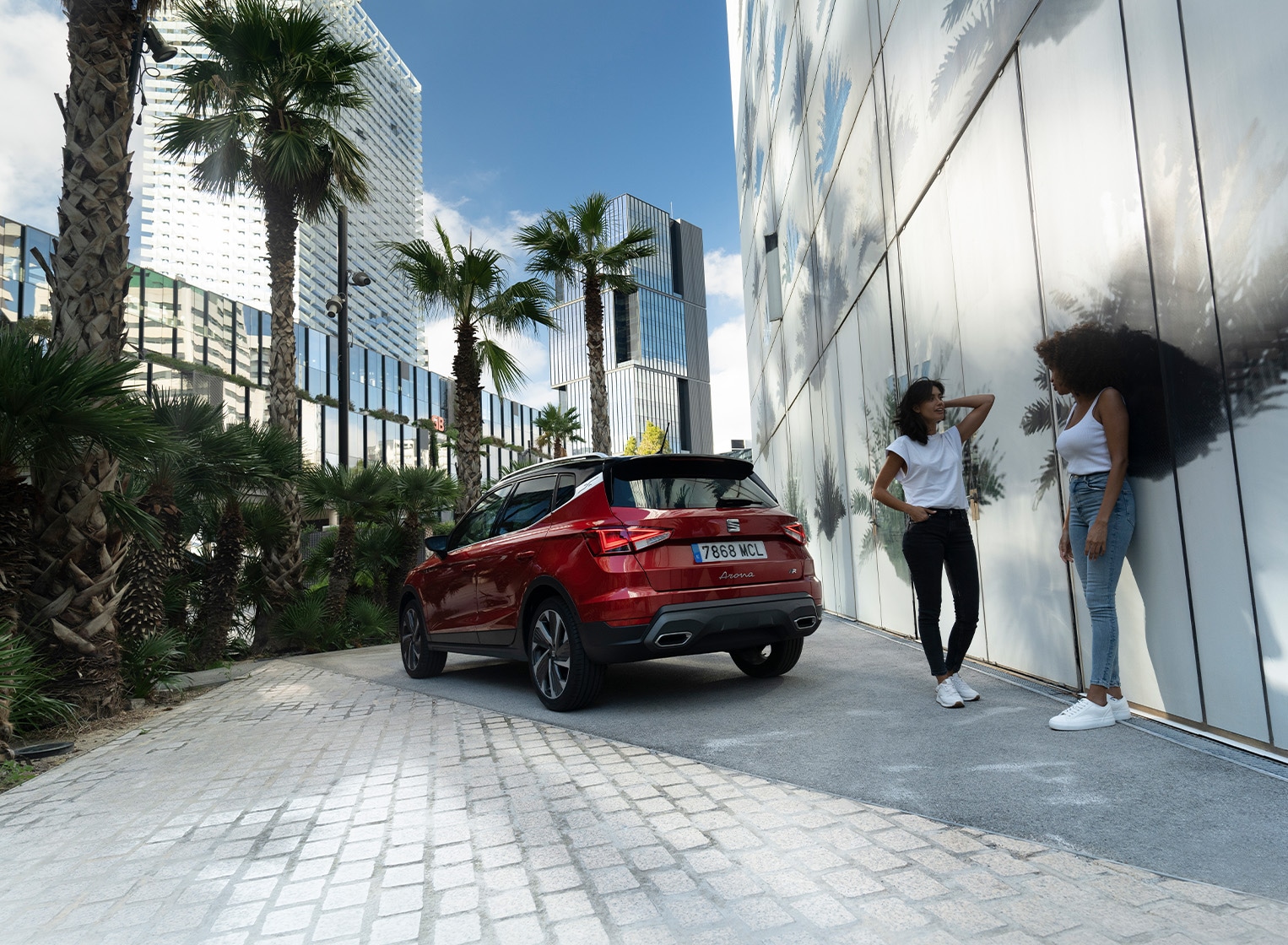 Vrouw en kind lopen richting een man die de kofferbak van een seat ateca aan het inpakken is
