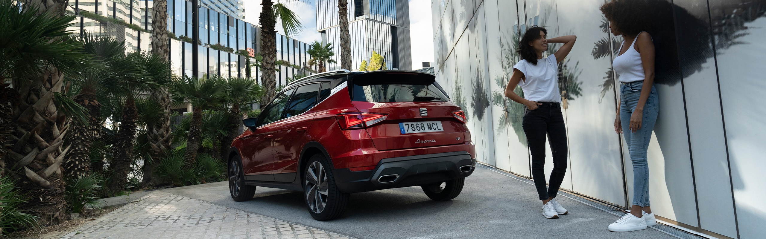 Vrouw met kind lopen richting een man die de kofferbak van een seat ateca aan het inpakken is