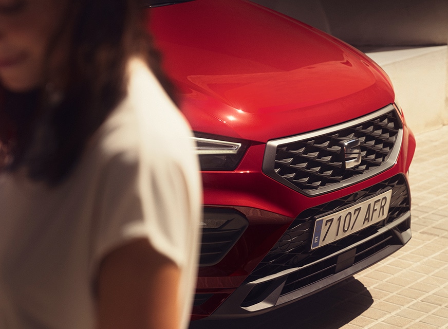 Vrouw met op de achtergrond rode SEAT Ateca