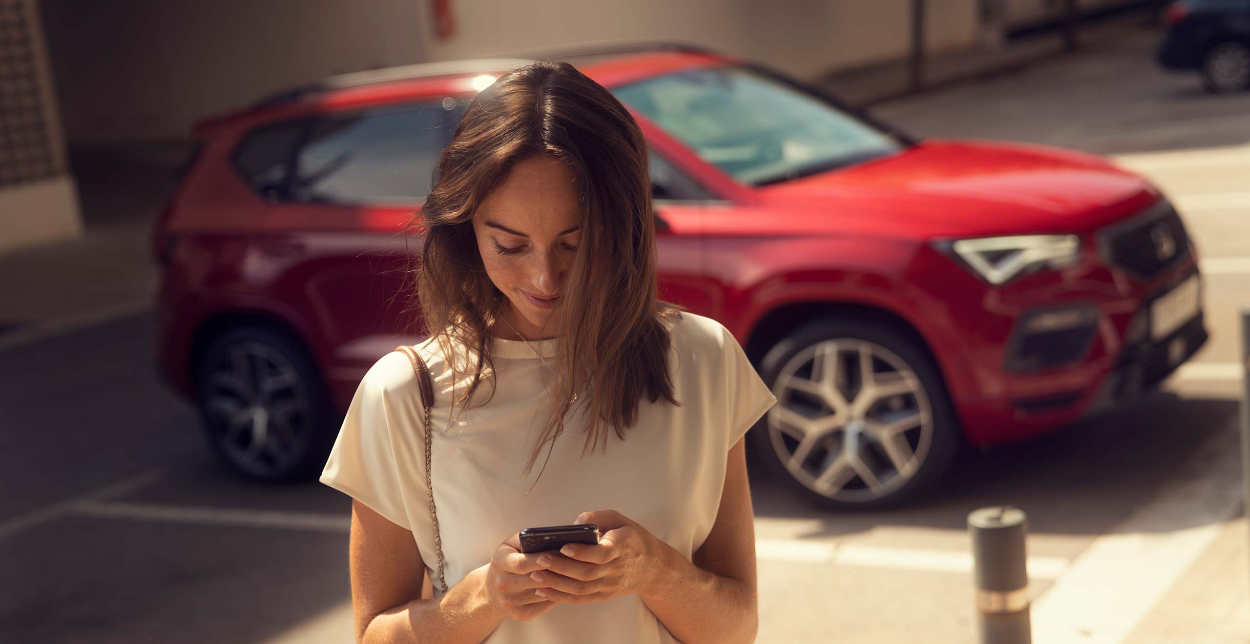 Glimlachende vrouw die voor SEAT Ateca staat