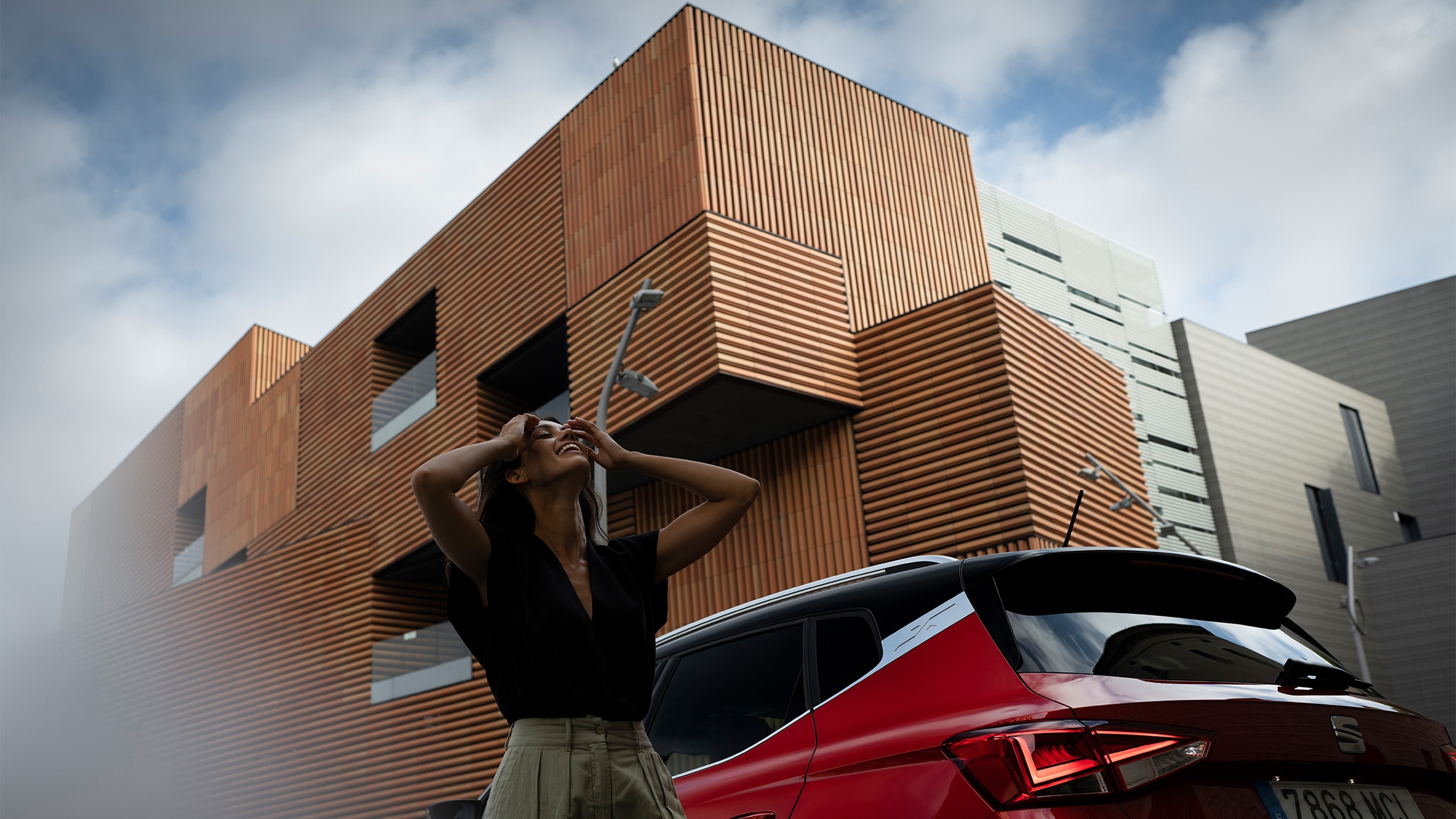 Vooraanzicht van rode SEAT Arona met koplampen aan