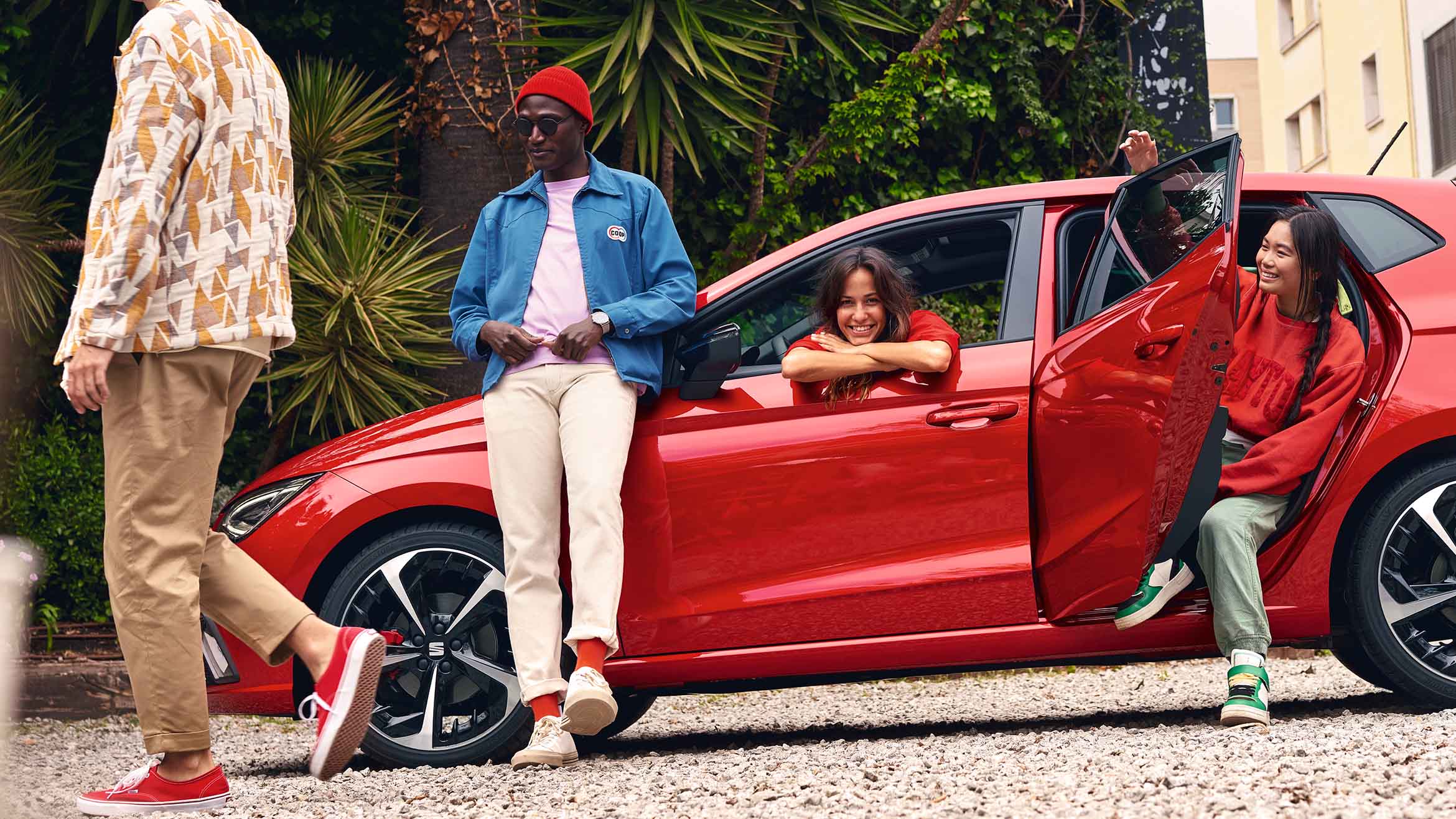 Vrienden die rondom een rode SEAT Ibiza hangen
