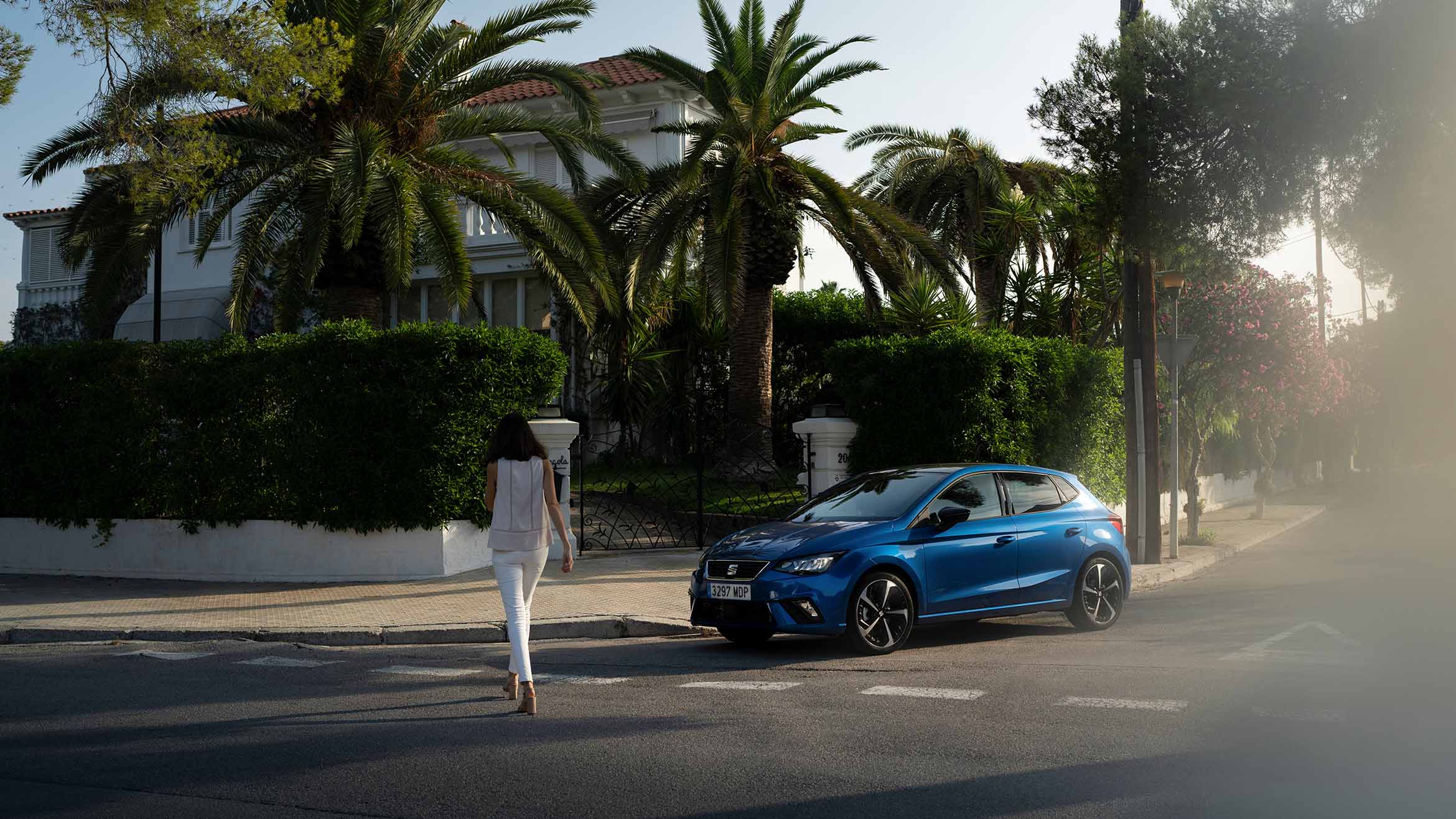 Vrouw lopend naast blauwe SEAT Ibiza