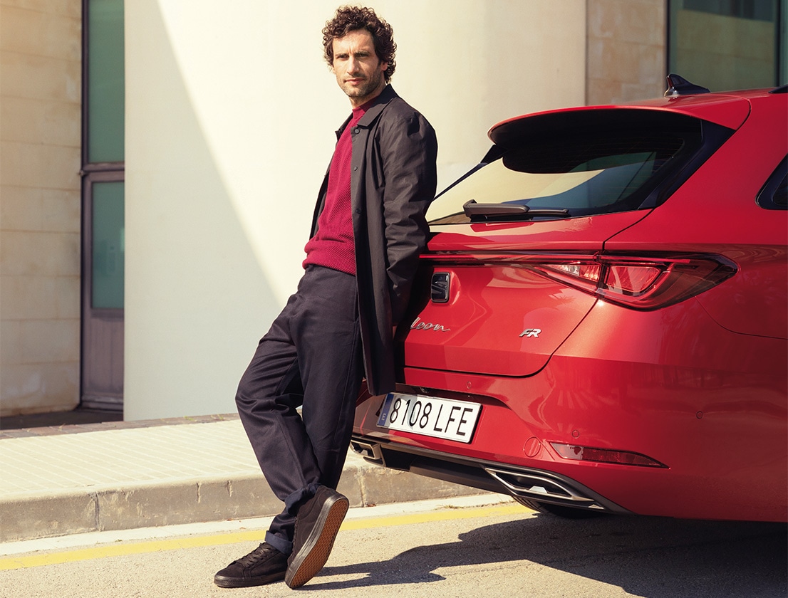 Man leaning against red SEAT Leon