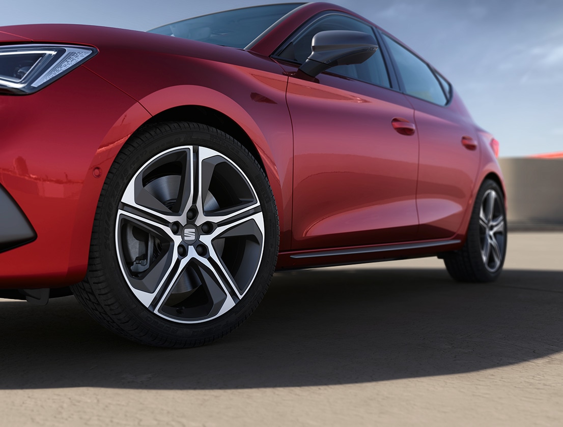 SEAT Leon hatchback 2025 plug in hybrid electric vehicle. Parked and charging outdoors, featuring spoke alloy wheels, interior ambient lighting and heated front seats for optimal comfort.
