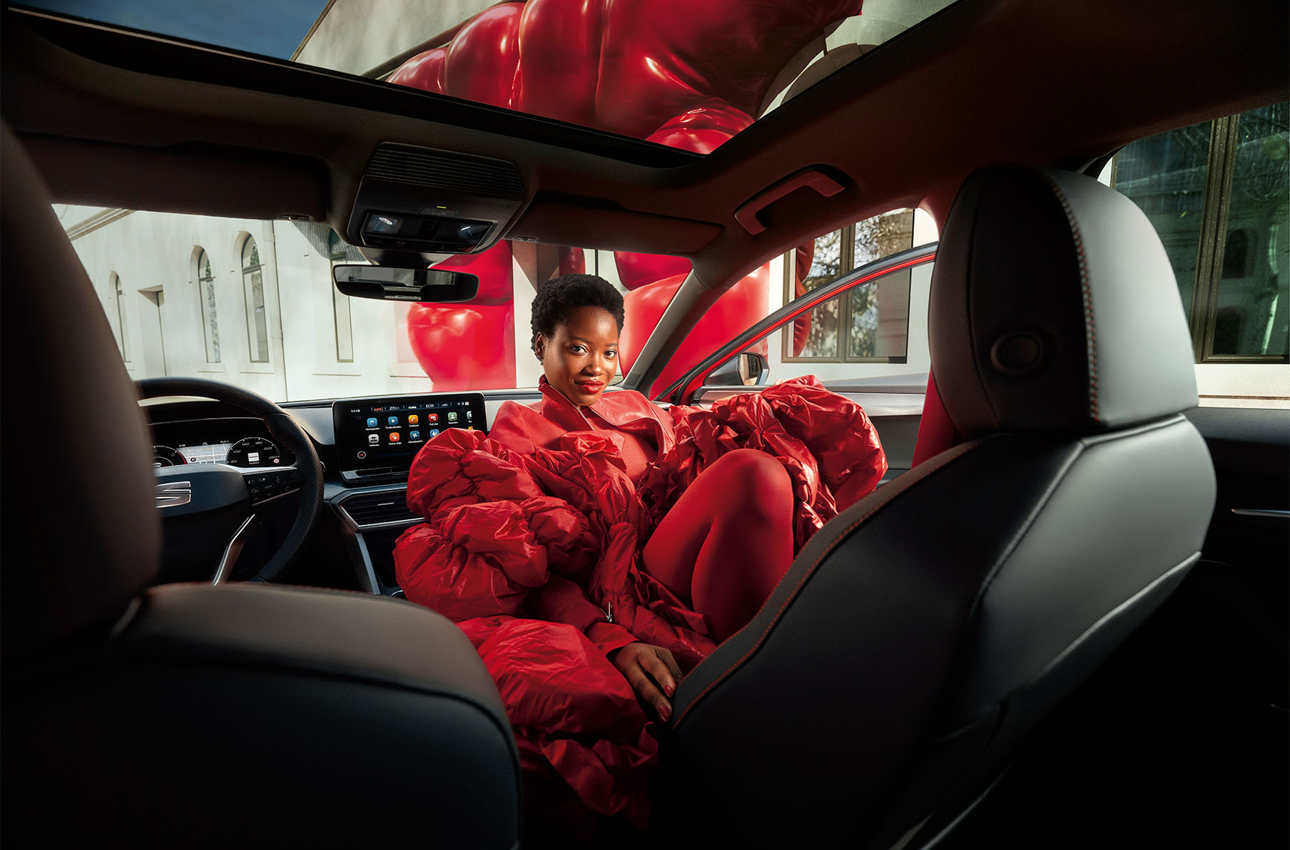 Vrouw in rood gewaad in de SEAT Leon
