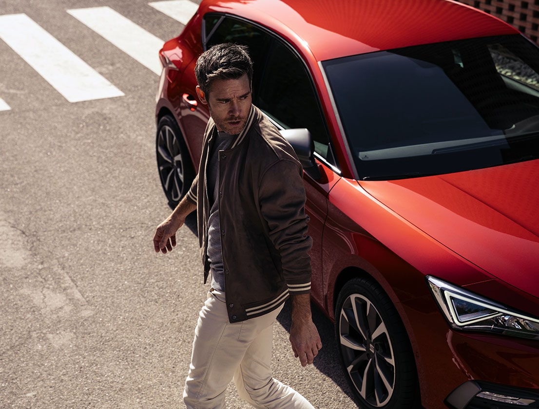 Man naast rode SEAT Leon