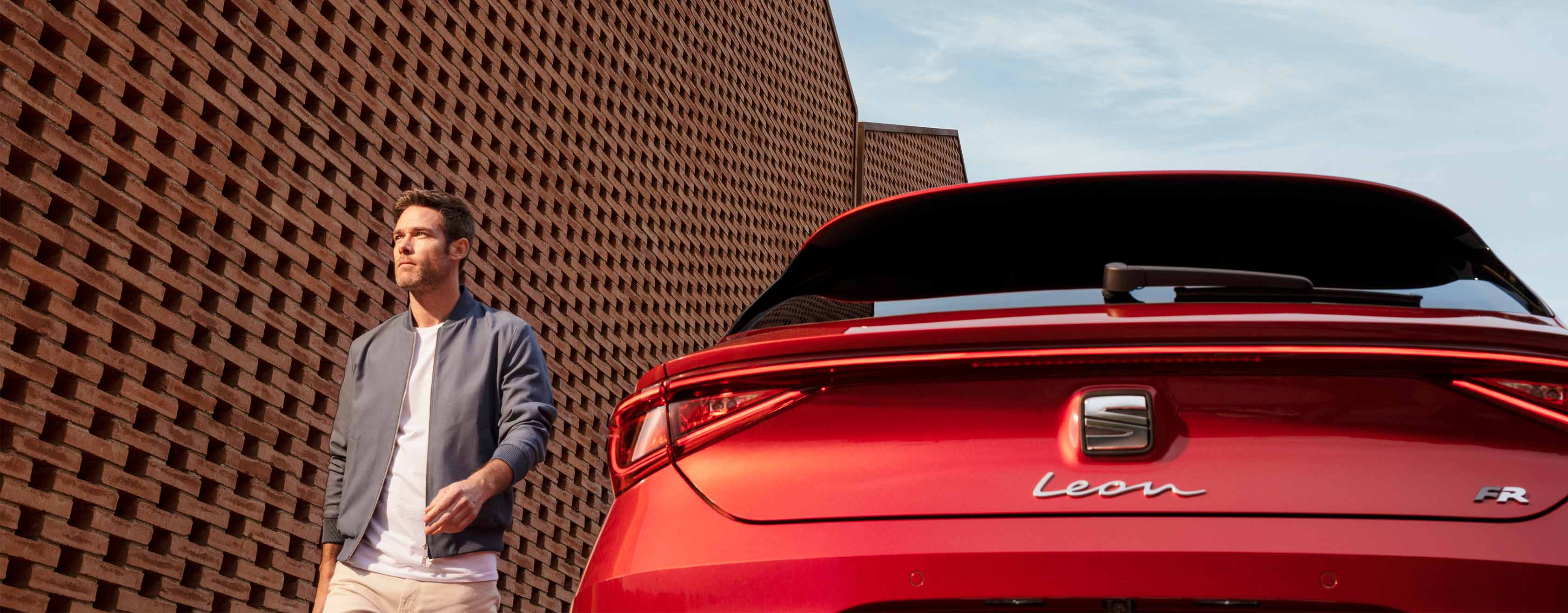 Man naast rode SEAT Leon