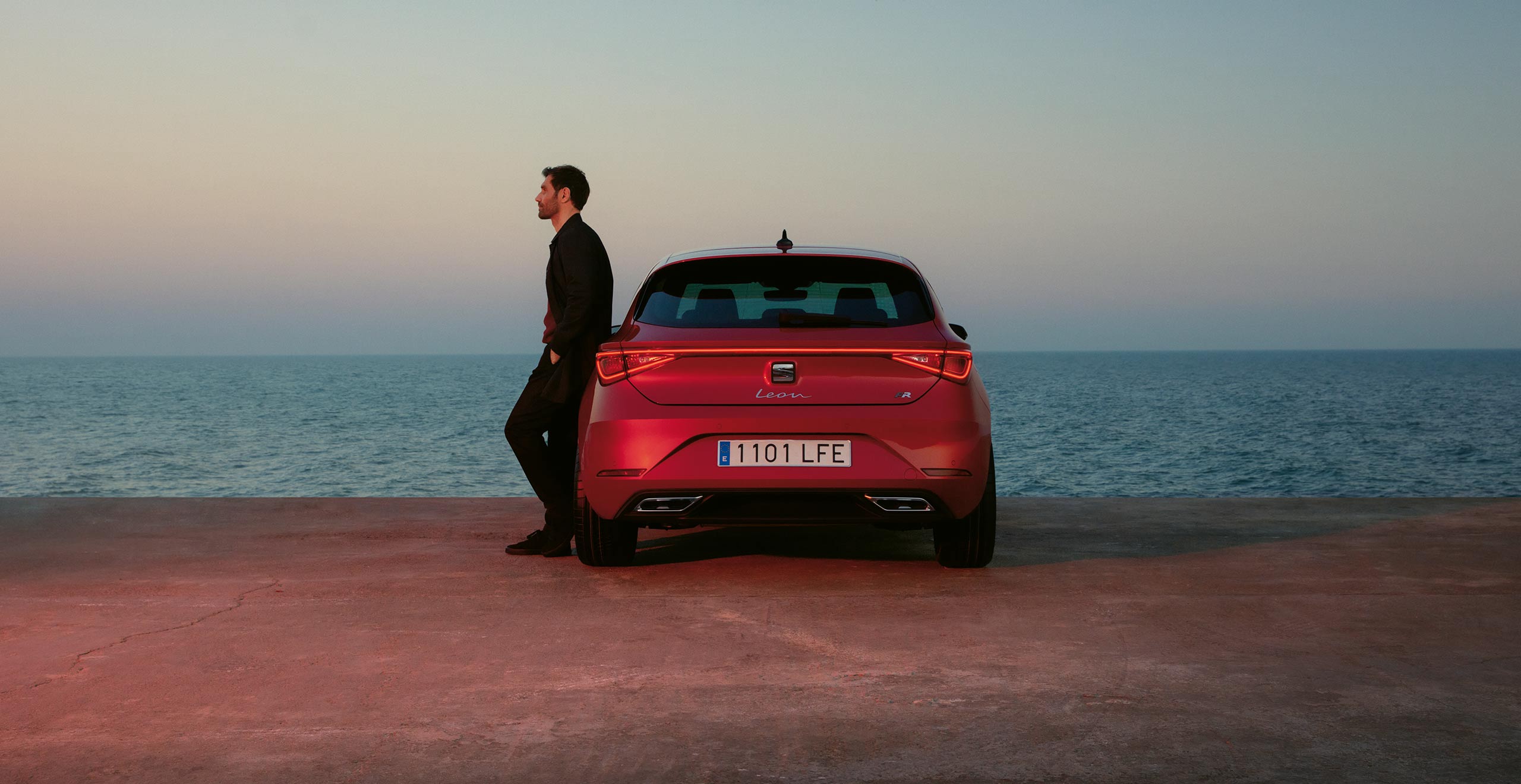 Man die tegen rode SEAT Leon FR leunt