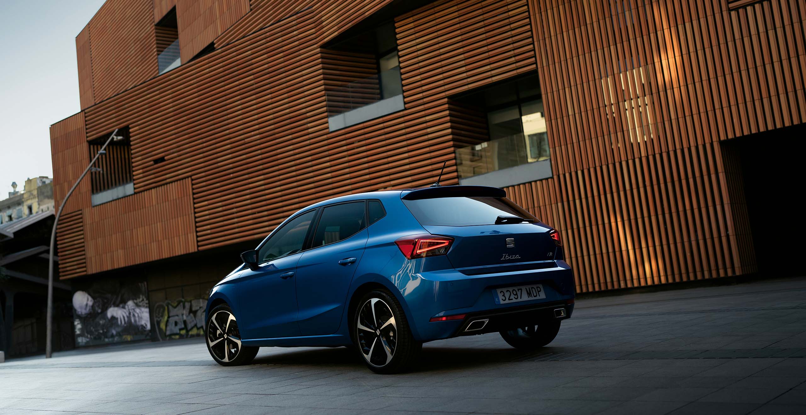 Blauwe SEAT Ibiza geparkeerd bij een kantoorgebouw