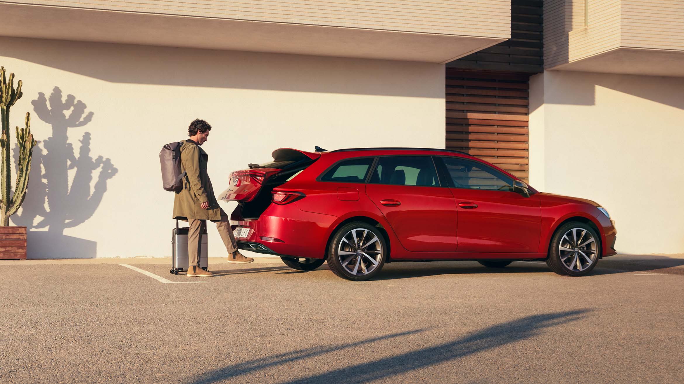 Man die met zijn voet de elektrische achterklep opent van de SEAT Leon Sportstourer