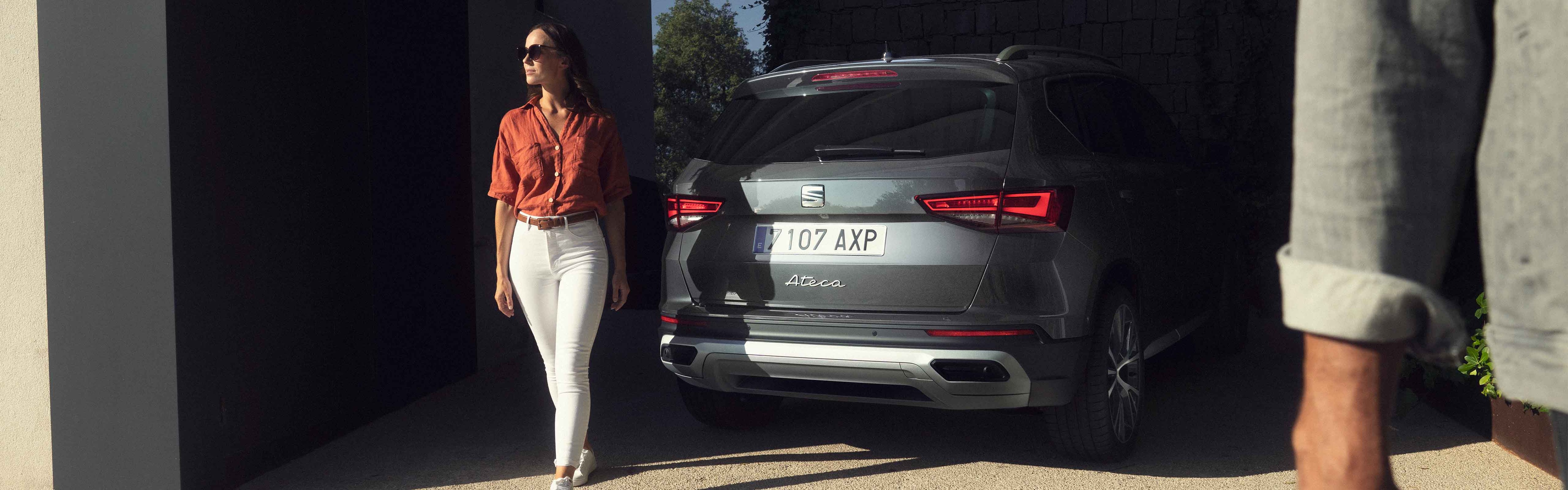 Vrouw loopt weg van een SEAT Ateca die net geparkeerd is